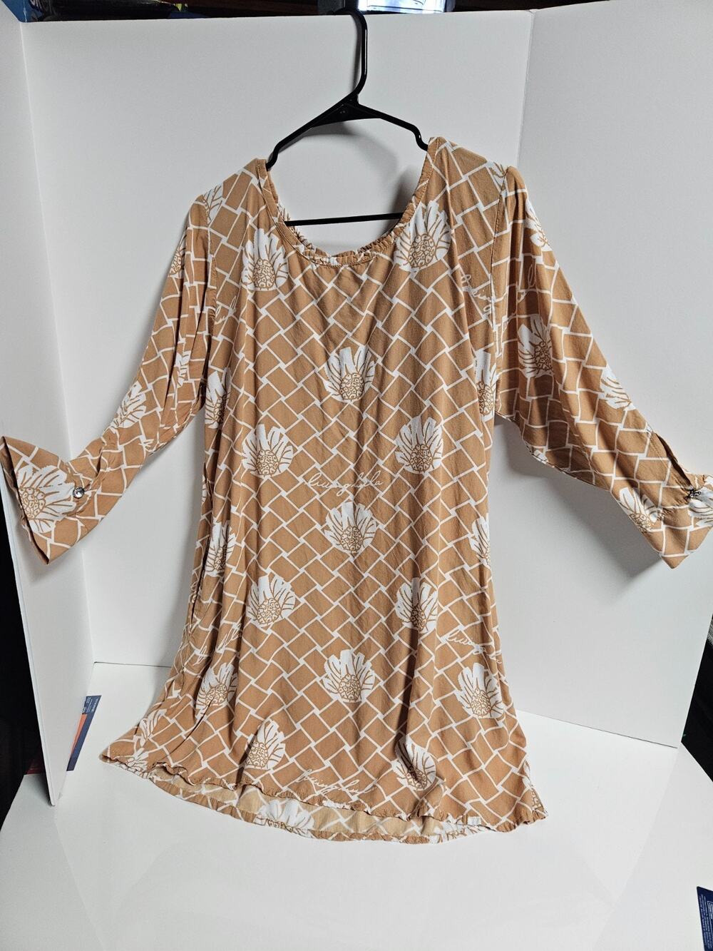 Living Hula dress tan background with a white floral and lattice pattern